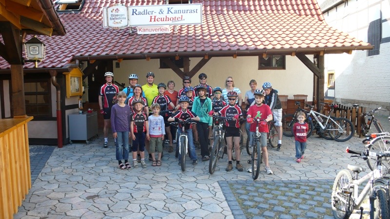 Gruppe mit Fahrrädern vor dem Eingang der Radler- und Kanurast Heuhotel